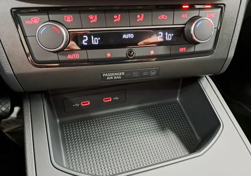 Gros plan sur la console centrale de la SEAT IBIZA 2024 noir minuit, montrant la climatisation automatique et deux ports USB rouges.