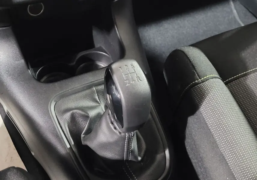 Gros plan sur le levier de vitesses manuel noir et la console centrale intérieure de la Citroën C3 beige 2022.