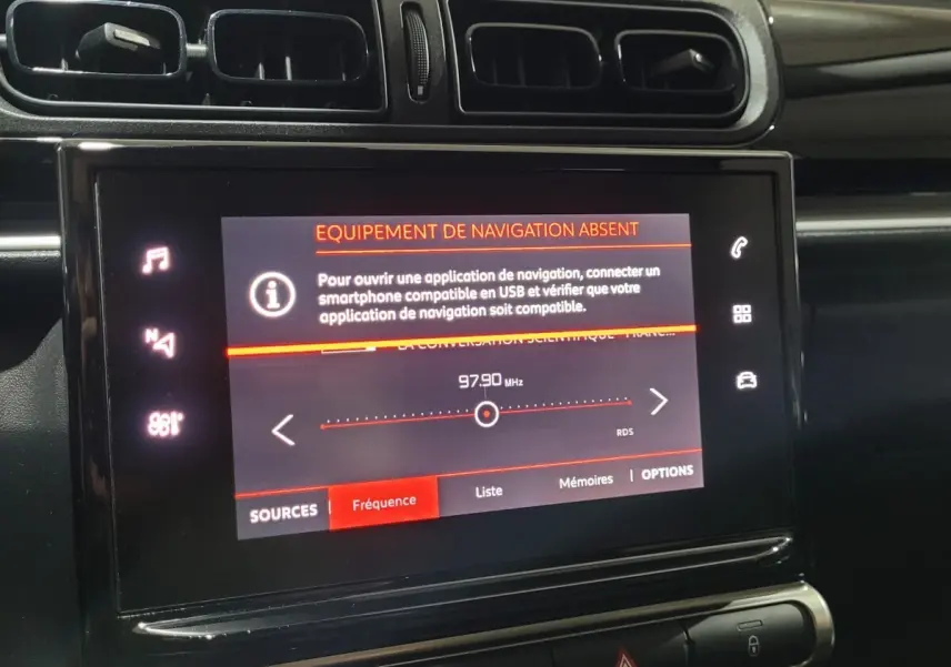 Vue rapprochée de l’écran tactile central de la Citroën C3 beige, affichant un message d’équipement de navigation absent.