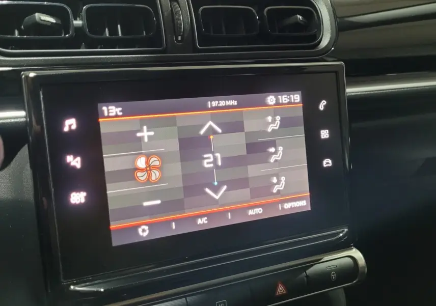 Vue rapprochée de l'écran tactile central de la Citroën C3 beige 2022 affichant la climatisation à 21°C.