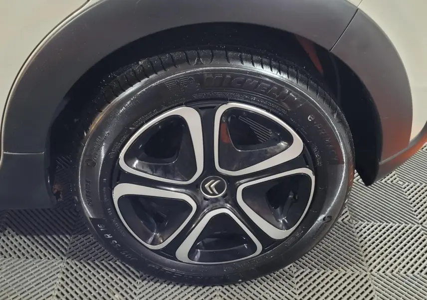 Gros plan sur la roue avant droite d'une Citroën C3 beige avec jante noire et argentée au design moderne.