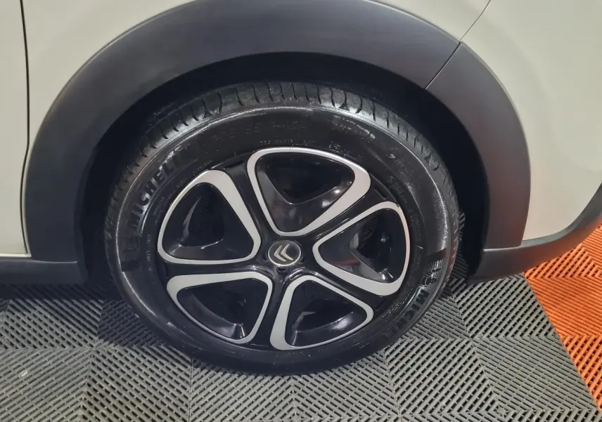 Gros plan sur la roue avant droite beige d'une Citroën C3 2022 avec jante noire et inserts argentés.