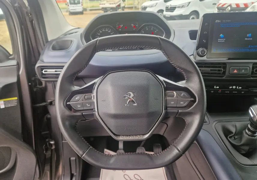 Vue intérieure centrée sur le volant cuir du Peugeot Rifter 2019, avec tableau de bord et écran tactile visibles.
