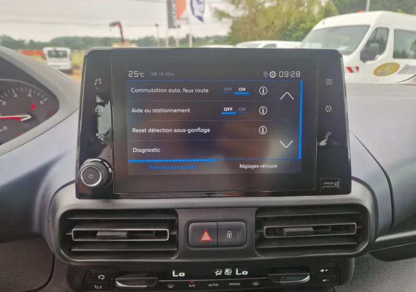 Vue intérieure centrée sur l'écran tactile du tableau de bord du Peugeot Rifter gris platinium, affichant les réglages d'aide à la conduite.