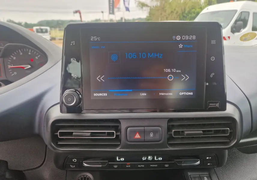 Vue intérieure centrée sur l’écran tactile multimédia du Peugeot Rifter gris platinium, affichant la radio FM à 106,10 MHz.