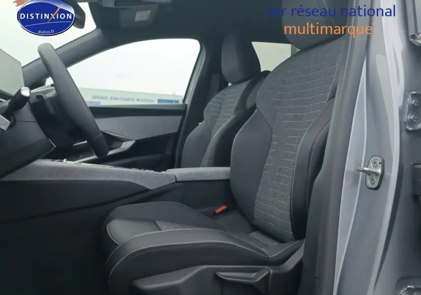 Vue intérieure côté conducteur du Peugeot 5008 gris artense, mettant en valeur les sièges tissu et cuir et le volant multifonction.