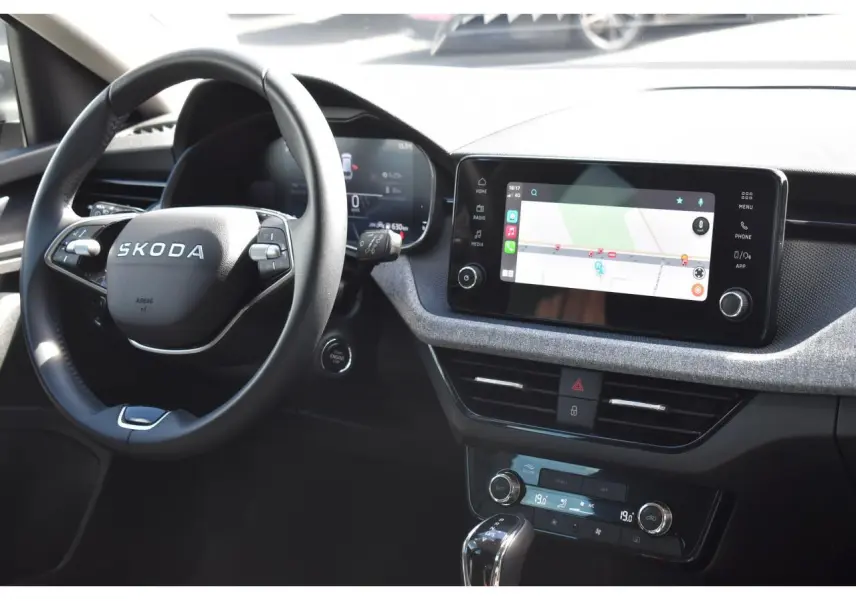 Vue intérieure du tableau de bord de la Skoda Scala gris graphite, avec écran tactile et volant cuir deux branches.