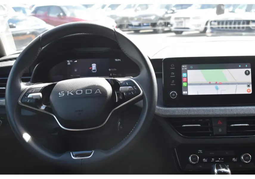 Vue intérieure centrée sur le volant cuir SKODA et l'écran tactile de navigation du tableau de bord.