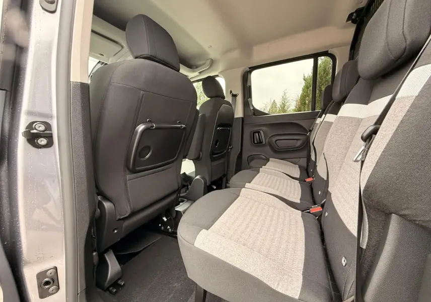 Vue intérieure côté droit sur la banquette arrière grise et noire du Citroën Berlingo Taille M 2025, avec porte ouverte.