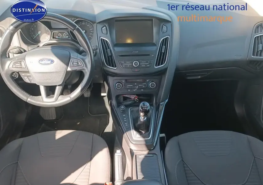 Vue intérieure avant de la Ford Focus 1.0 Ecoboost 125 Titanium 2017, volant cuir et console centrale avec boîte manuelle.