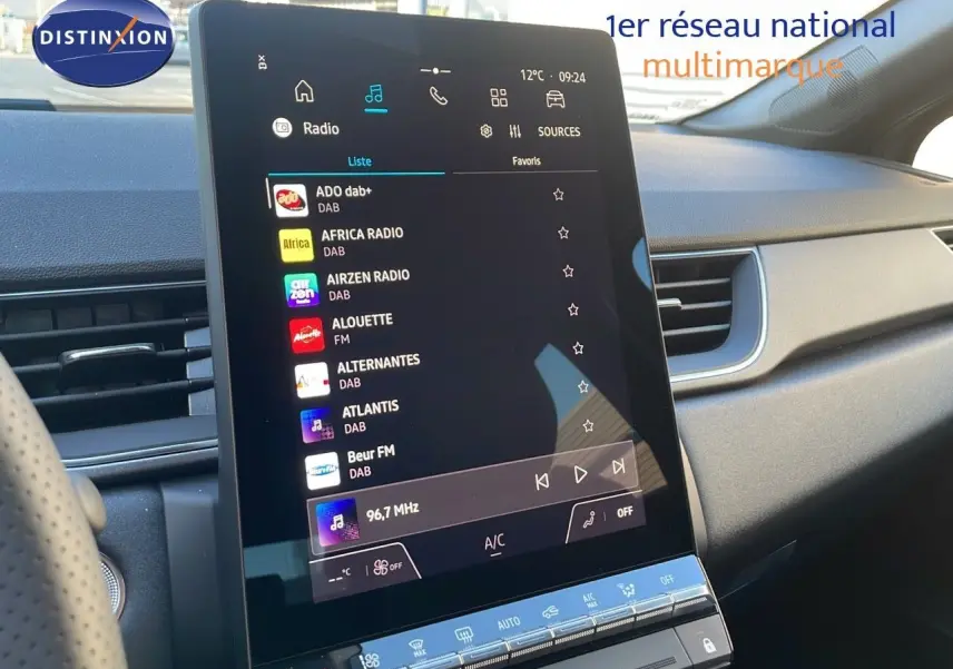 Vue rapprochée de l'écran tactile central du tableau de bord du Renault Captur gris cassiopée 2025 affichant les stations radio DAB.