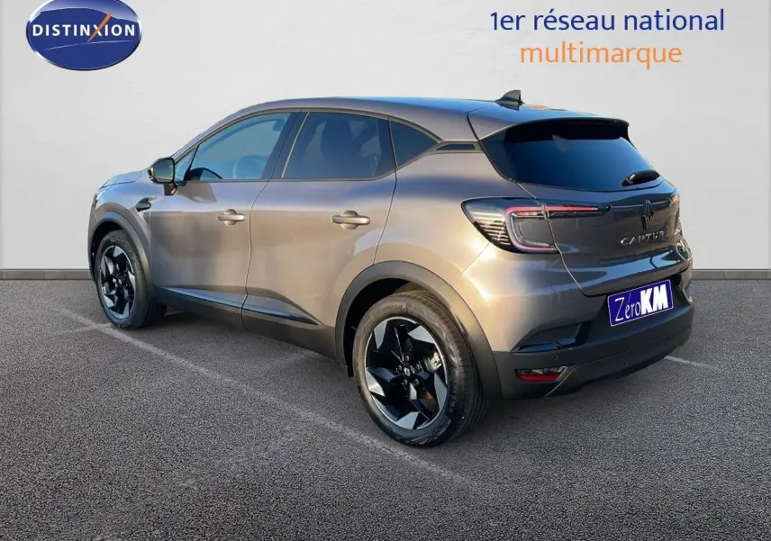 Renault Captur E-Tech hybride gris cassiopée métal vu en 3/4 arrière côté gauche avec jantes noires distinctives.
