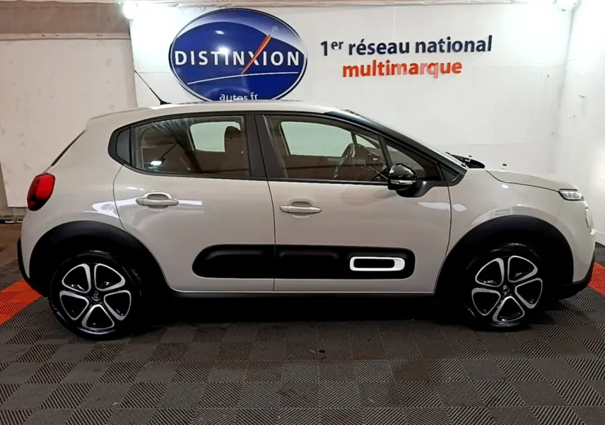 Vue latérale droite d'une Citroën C3 beige 2022 avec protections noires sur les portières et jantes stylisées.
