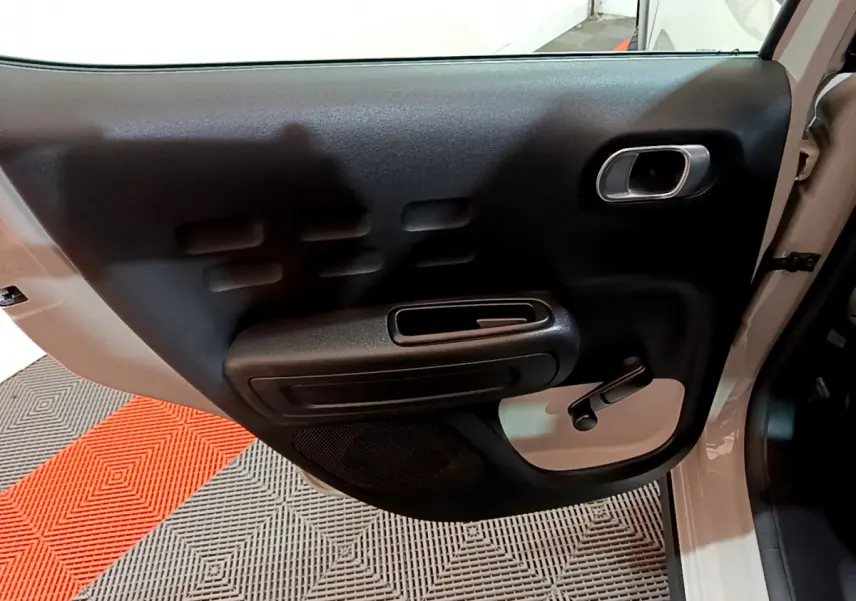 Vue rapprochée de la porte arrière gauche beige de la Citroën C3 2022 avec poignée de fenêtre manuelle noire.