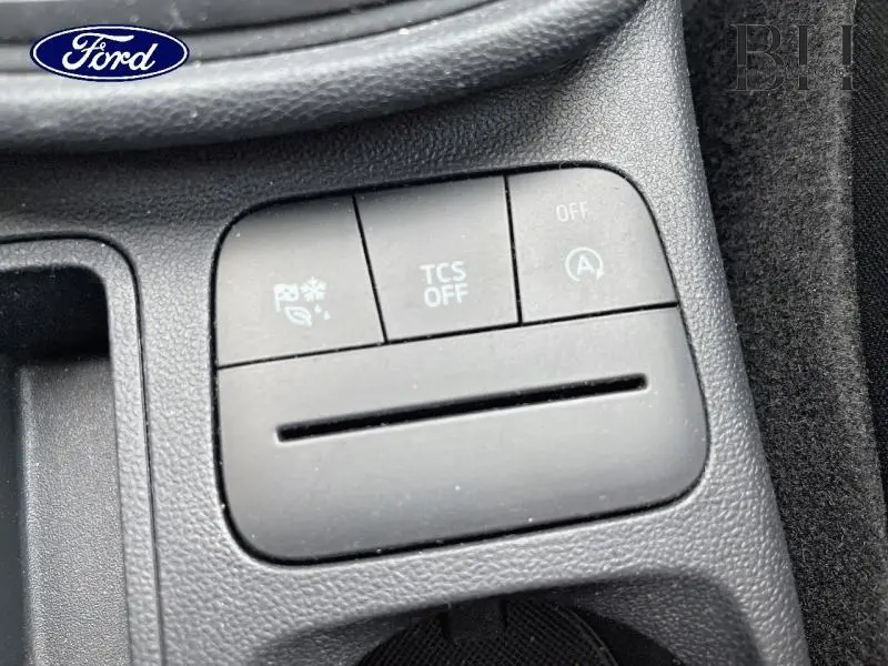 Gros plan sur les boutons de commande du système d’aide au stationnement et de l’arrêt automatique du moteur dans une Ford Fiesta gris lunaire.