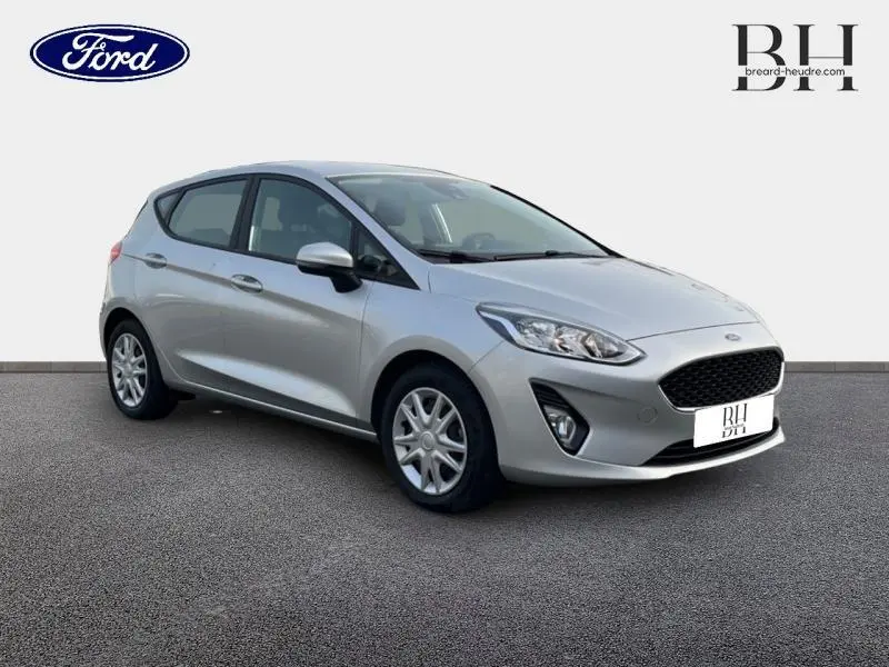 Vue 3/4 avant droit d'une Ford Fiesta 2020 gris lunaire avec enjoliveurs et boucliers ton carrosserie.