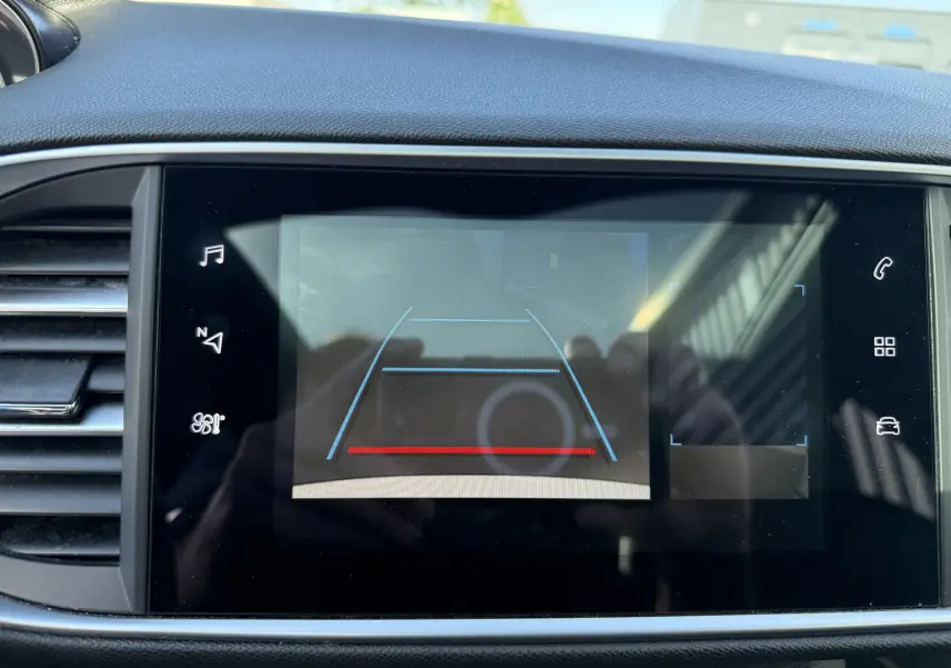 Écran tactile intérieur de la Peugeot 308 SW 2021 montrant la caméra de recul avec lignes de guidage colorées.