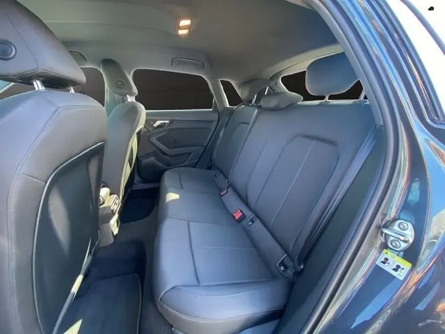 Vue intérieure côté droit montrant la banquette arrière en cuir gris foncé de l'Audi A3 30 TDI Business Line 2021.
