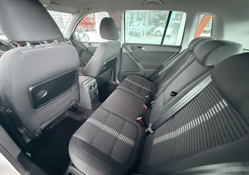 Vue intérieure arrière du Volkswagen Tiguan 2.0 TDI 140 de 2010, sièges en tissu noir avec motifs clairs.