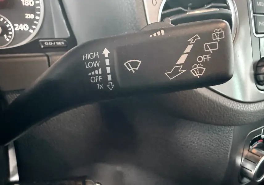Gros plan sur la manette de commande des essuie-glaces du Volkswagen Tiguan 2010, intérieur noir.