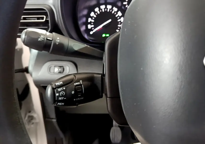 Gros plan sur le volant et les commandes de régulateur de vitesse du Citroën Berlingo blanc, version XL PureTech 2019.