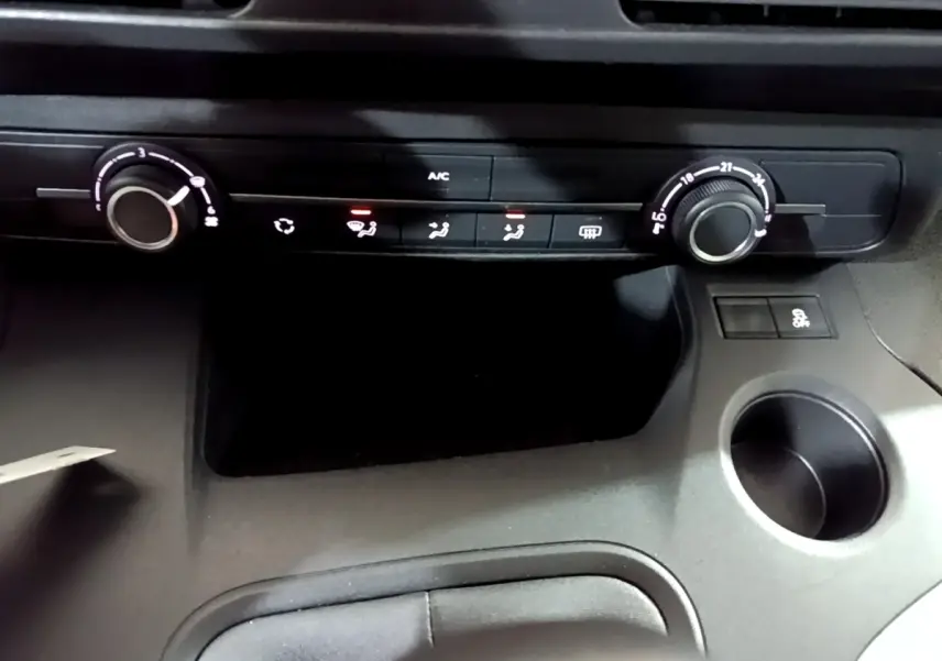 Détail de la console centrale avec commandes de climatisation et bouton antipatinage du Citroën Berlingo XL blanc 2019.