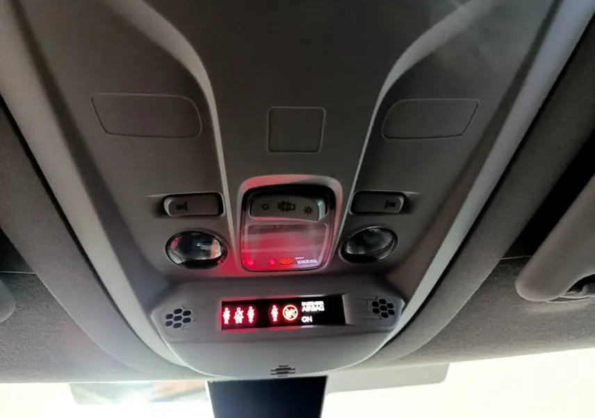 Vue intérieure du plafonnier gris avec commandes d’éclairage et affichage des ceintures de sécurité allumées.