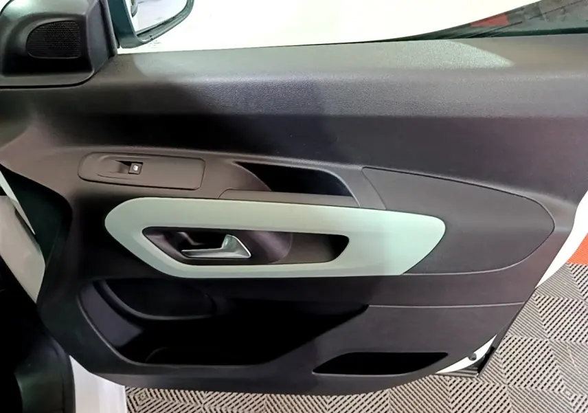 Vue rapprochée de la porte avant gauche blanche du Citroën Berlingo XL 2019 avec poignée intérieure grise.
