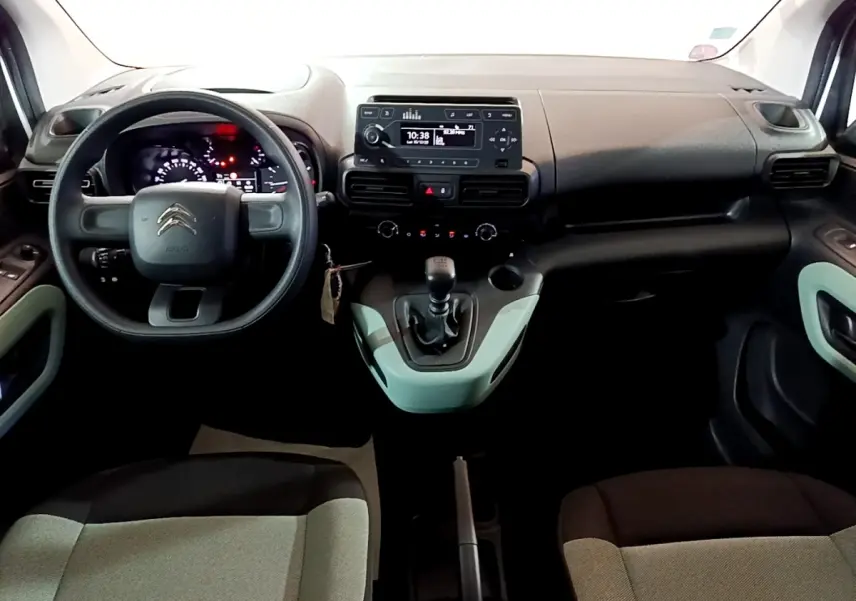 Vue intérieure avant du Citroën Berlingo XL 2019, tableau de bord noir avec volant et levier de vitesses manuels.