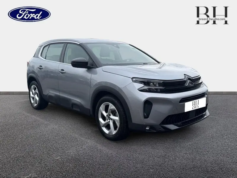 Citroën C5 Aircross gris acier en 3/4 avant droit, avec jantes alu et signature lumineuse LED distinctive.