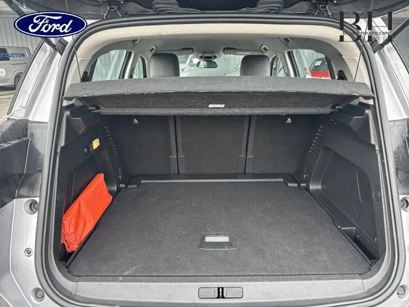 Vue arrière du coffre ouvert du Citroën C5 Aircross gris acier 2023, montrant l'espace de chargement et la tablette cache-bagages.