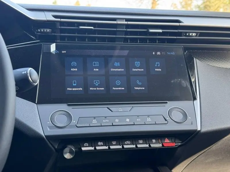 Vue rapprochée de la console centrale tactile de la Peugeot 308 2025, avec commandes climatisation et boutons multifonctions.