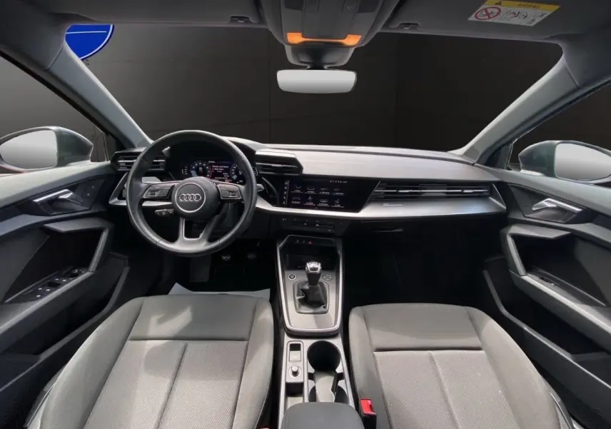 Vue intérieure frontale de l'Audi A3 30 TFSI S Line 2021 avec volant cuir, tableau de bord numérique et boîte manuelle.
