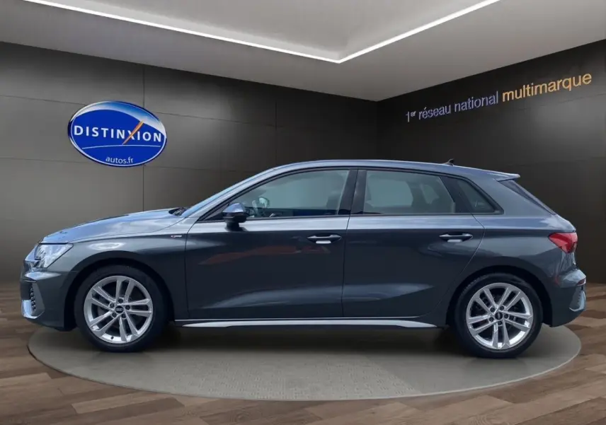 Profil côté gauche d'une Audi A3 30 TFSI S Line gris foncé, avec jantes alliage et rétroviseurs électriques rabattables.