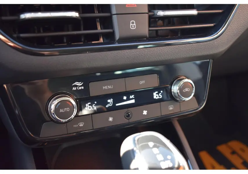 Gros plan sur la console centrale de la Skoda Scala blanche, affichant la climatisation digitale à 16,5°C et la boîte auto.