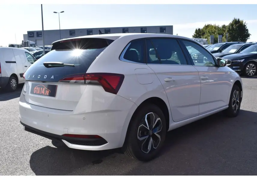 Vue 3/4 arrière droite d'une Skoda Scala blanche Glacier avec vitres surteintées et jantes originales.