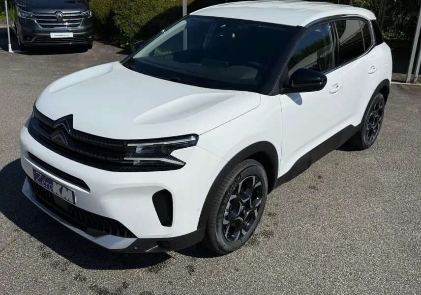 Citroën C5 Aircross blanc banquise en vue 3/4 avant droit, avec jantes noires et toit contrasté noir.
