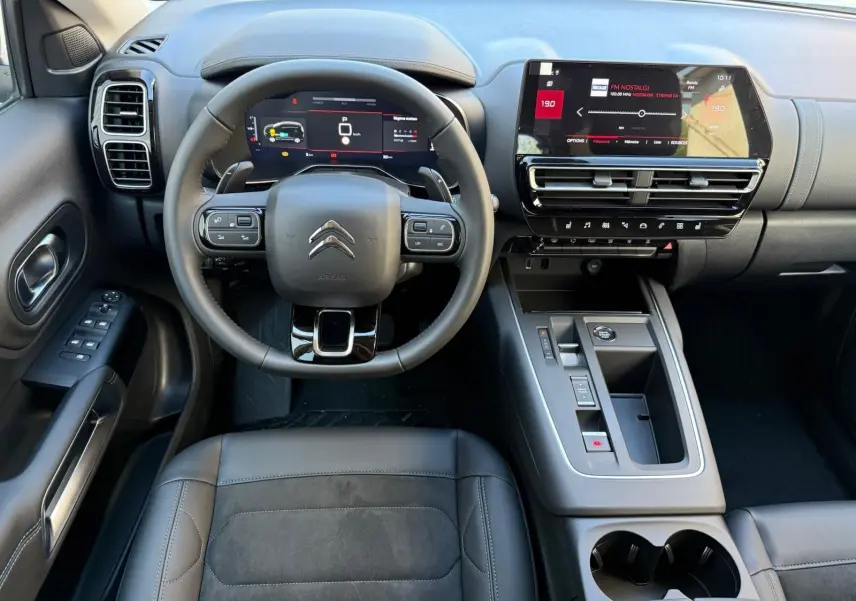 Vue intérieure frontale du tableau de bord du Citroën C5 Aircross blanc banquise 2024, avec écran tactile et volant multifonction.