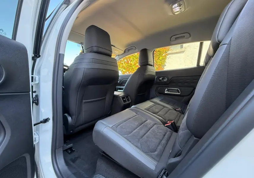 Vue intérieure côté droit arrière du Citroën C5 Aircross blanc banquise, sièges arrière en tissu et cuir noir.