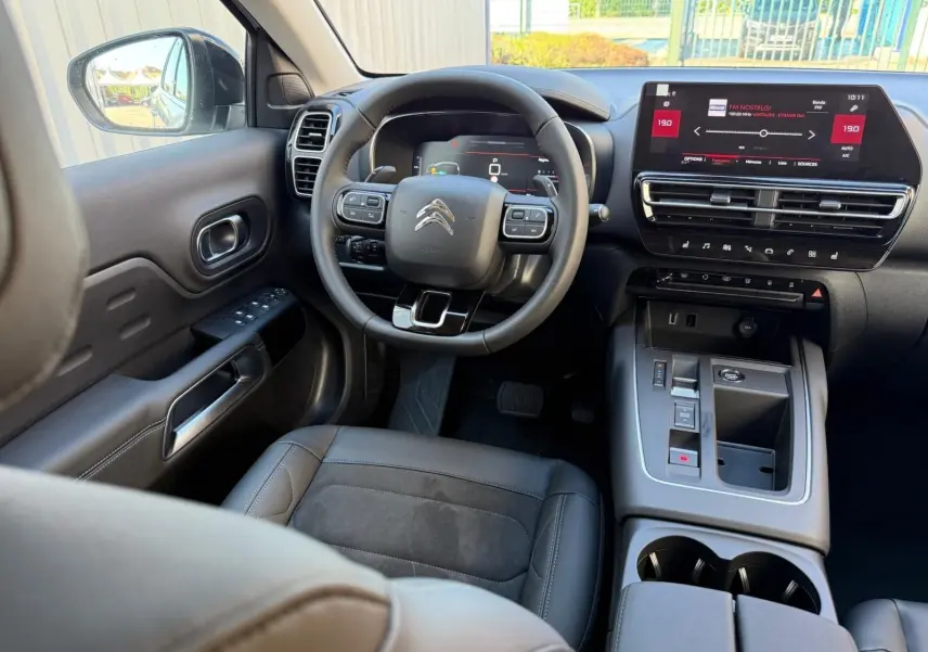 Vue intérieure du poste de conduite du Citroën C5 Aircross blanc banquise, avec tableau de bord numérique et écran tactile central.