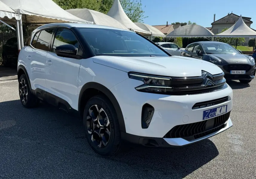 Citroën C5 Aircross blanc banquise en 3/4 avant droit, avec jantes noires et toit contrasté noir.