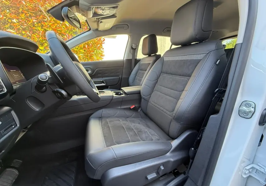 Vue côté conducteur de l'intérieur du Citroën C5 Aircross blanc banquise, sièges cuir et alcantara noirs avec surpiqûres grises.