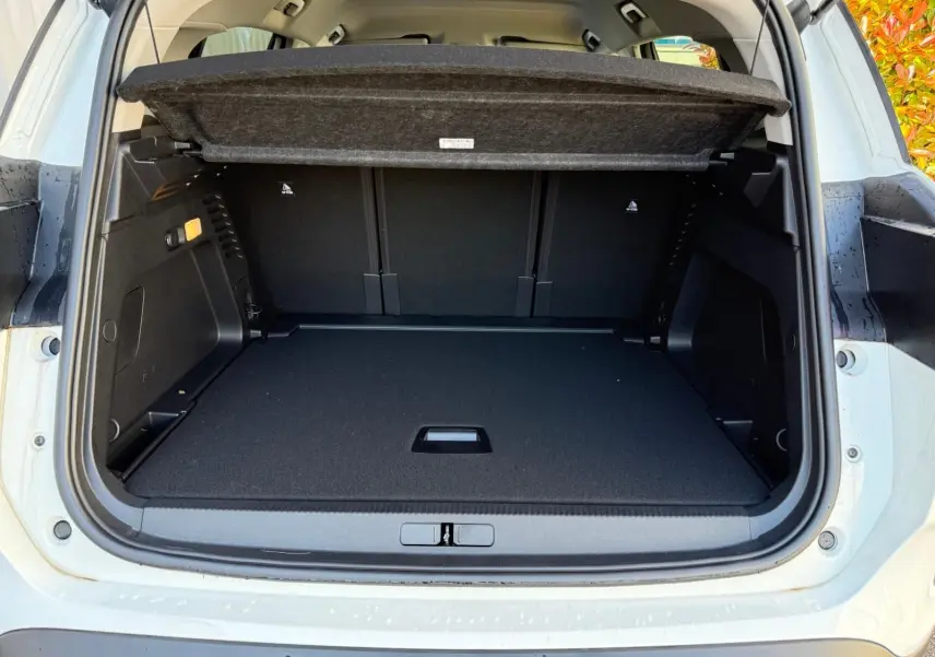 Coffre ouvert vu de l'arrière d'un Citroën C5 Aircross blanc banquise, espace de chargement spacieux et couvert amovible.