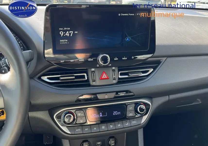 Vue rapprochée du tableau de bord de la Hyundai i30 2024 avec écran tactile et commandes de climatisation bi-zone.