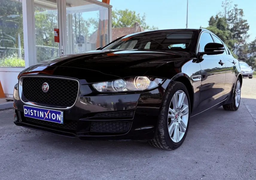 Jaguar XE noir vu en 3/4 avant droit, mettant en valeur sa calandre distinctive et ses jantes argentées.