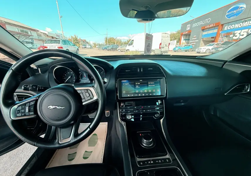 Intérieur noir de la Jaguar XE 2019 vu côté conducteur, avec tableau de bord digital et écran tactile central.