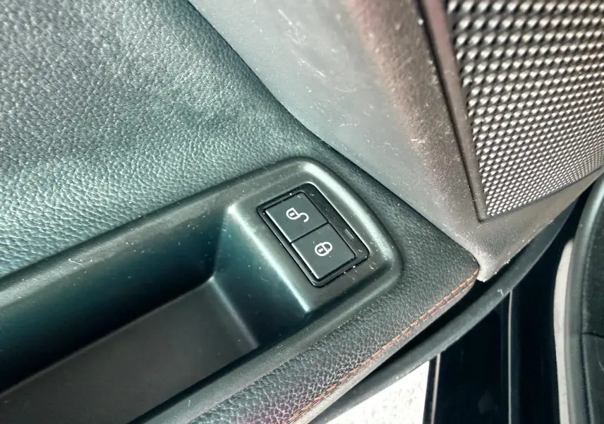 Boutons de verrouillage des portes sur la garniture intérieure noire côté conducteur d'une Jaguar XE 2019.