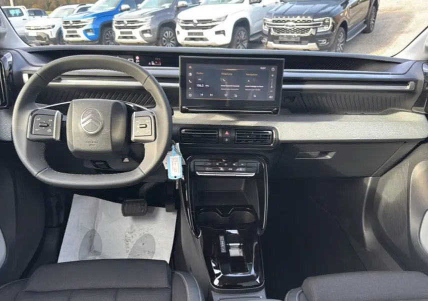 Vue intérieure frontale du tableau de bord et volant cuir noir du Citroën C3 Aircross Hybrid 145 2025.