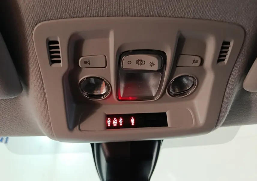Vue en gros plan du plafonnier intérieur gris clair de la Citroën C3 avec commandes d’éclairage et indicateurs rouges allumés.
