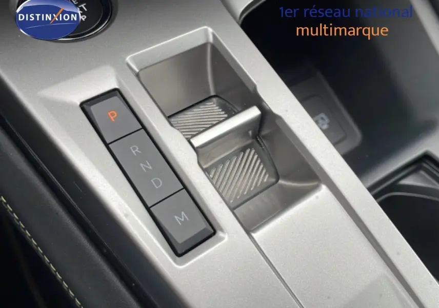 Gros plan sur la console centrale argentée du Peugeot 408 Hybrid 145ch, avec sélecteur de boîte automatique et boutons de vitesses.